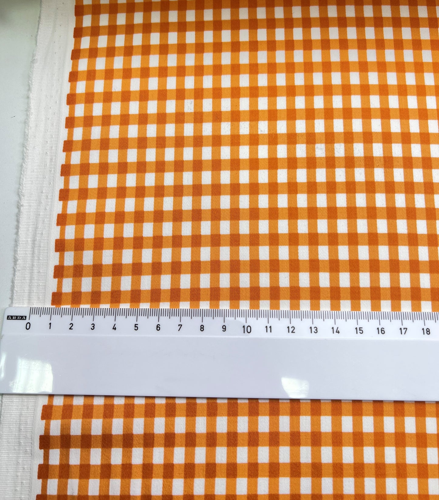 Cotone elasticizzato quadretti arancioni su sfondo bianco